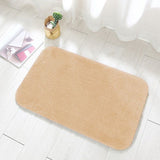 Camel colored flannel floor mat at the entrance of a bedroom beside a bed
