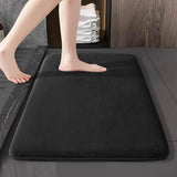 Wine red flannel bathroom mat outside a bathtub on a modern bathroom floor