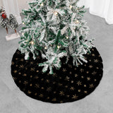 Black velvet Christmas tree skirt placed under decorated holiday tree
