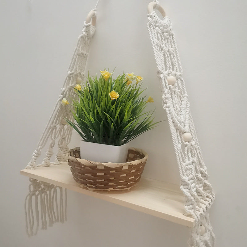 Cotton wall tapestry shelf displayed on a balcony wall with a small dried flower arrangement