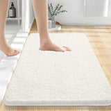 Beige chenille floor mat placed in front of a shower in a clean modern bathroom