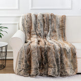 Faux fur throw blanket in brown draped over bed showing soft plush texture