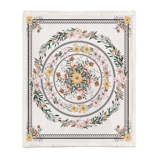 Large floral throw blanket layered at the foot of a white bed in a bright bedroom