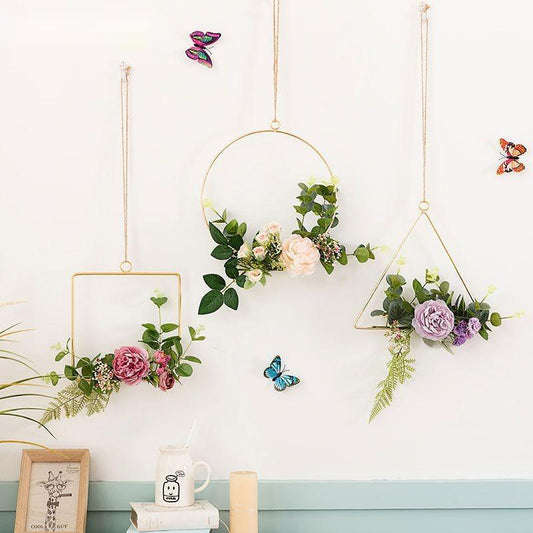 Iron and artificial flower wall art hanging above a bedroom headboard as a decorative accent