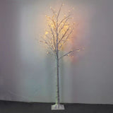 LED birch tree lights glowing beside window