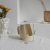 Matte ceramic vase in a Japandi styled shelf display with minimal objects and warm lighting