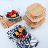 Microwave safe bento box with compartments filled with food on wooden surface