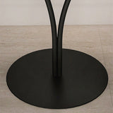 Small Nordic round metal side table beside a reading chair in a bedroom corner