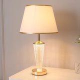 Post modern luxury table lamp gold base white fabric shade in bedroom setting
