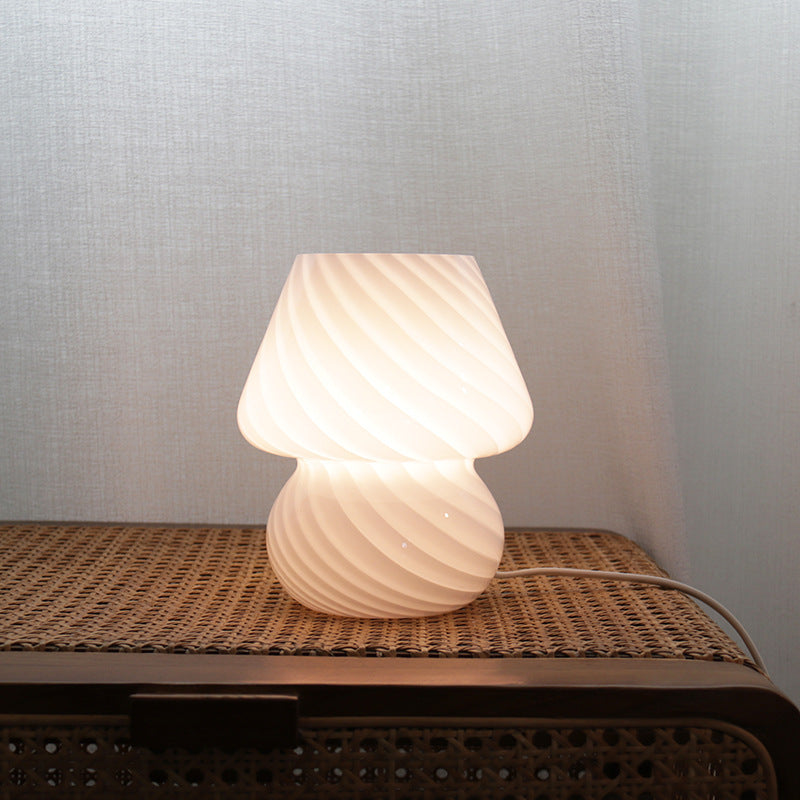Frosted button pattern retro glass table lamp casting soft diffused light on a desk