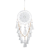 Romantic decorative dream catcher hanging beside a bedroom window in a boho styled room
