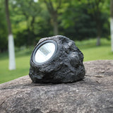 Solar simulation rock garden light placed on outdoor courtyard stone