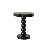 Vintage solid wood round side table holding a lamp, book, and phone as a bedside surface