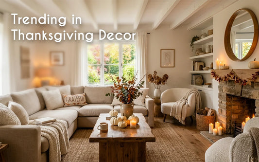 Thanksgiving home decor with a styled dining table, warm candles, dried stems in a vase, and cozy autumn colors