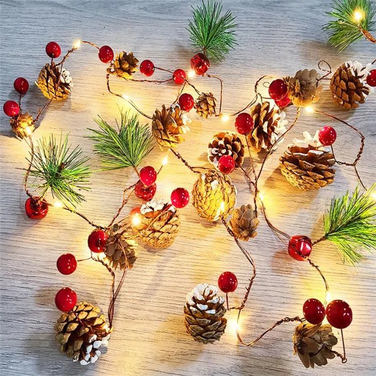 Decorative string lights with pine cones and berries on a wooden surface