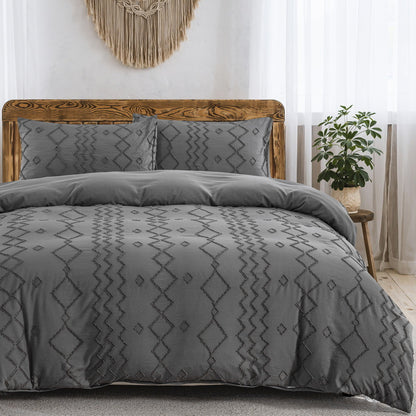 Gray patterned bedding set on a bed in a bedroom with a wooden headboard and decorative wall hanging.