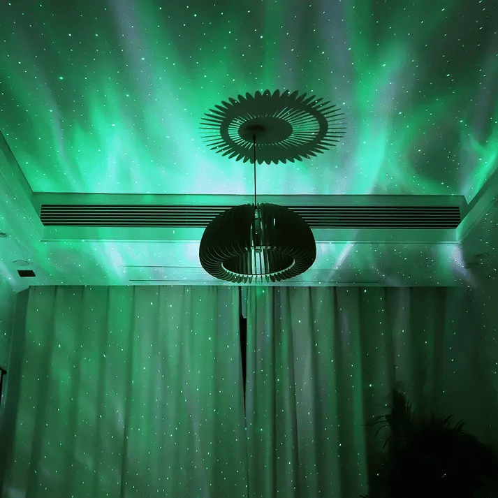 Aurora projector lamp projecting pink northern lights on ceiling