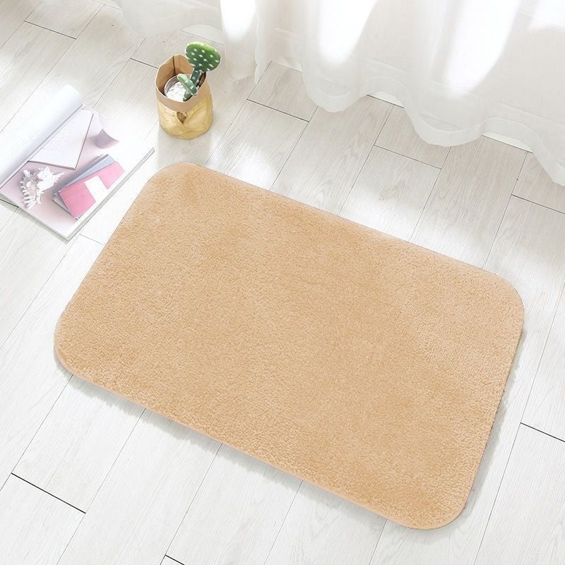 Camel colored flannel floor mat at the entrance of a bedroom beside a bed
