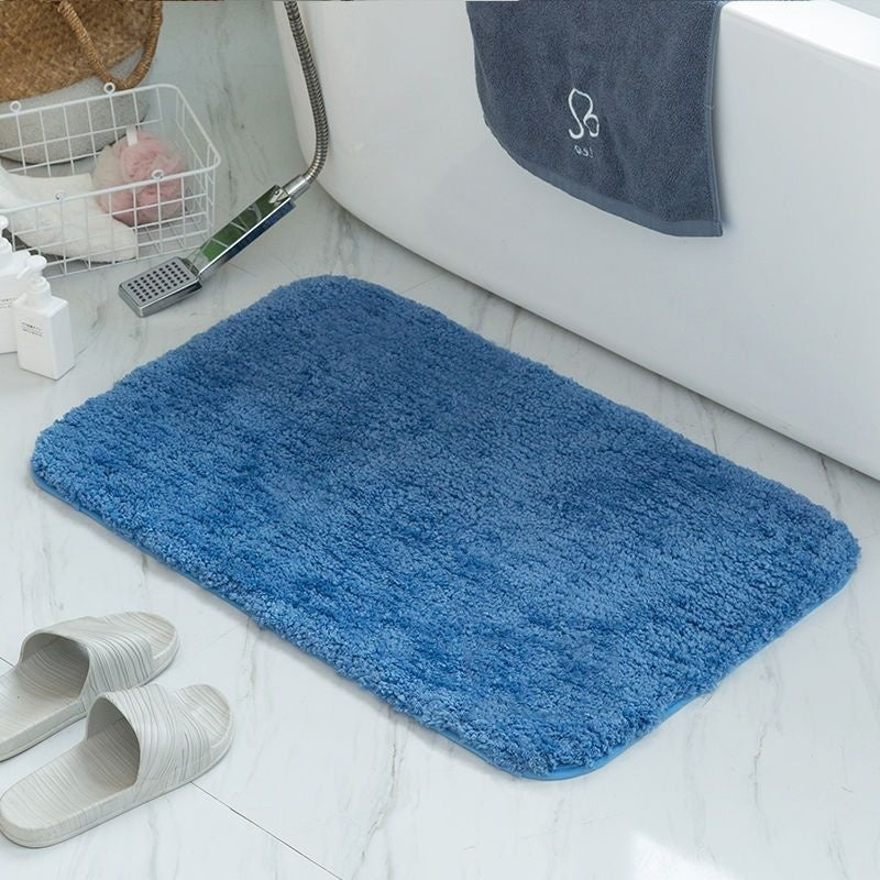 Sky blue absorbent flannel floor mat in front of a bathroom sink on light tile
