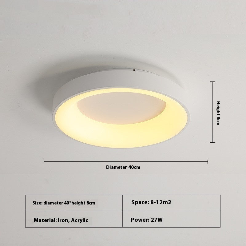 Modern minimalist flush mount ceiling lamp in a Nordic styled bedroom with linen bedding

