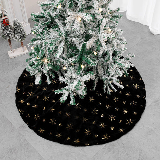 Black velvet Christmas tree skirt placed under decorated holiday tree