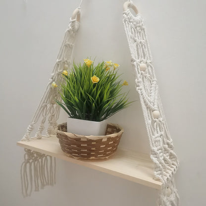 Cotton wall tapestry shelf displayed on a balcony wall with a small dried flower arrangement