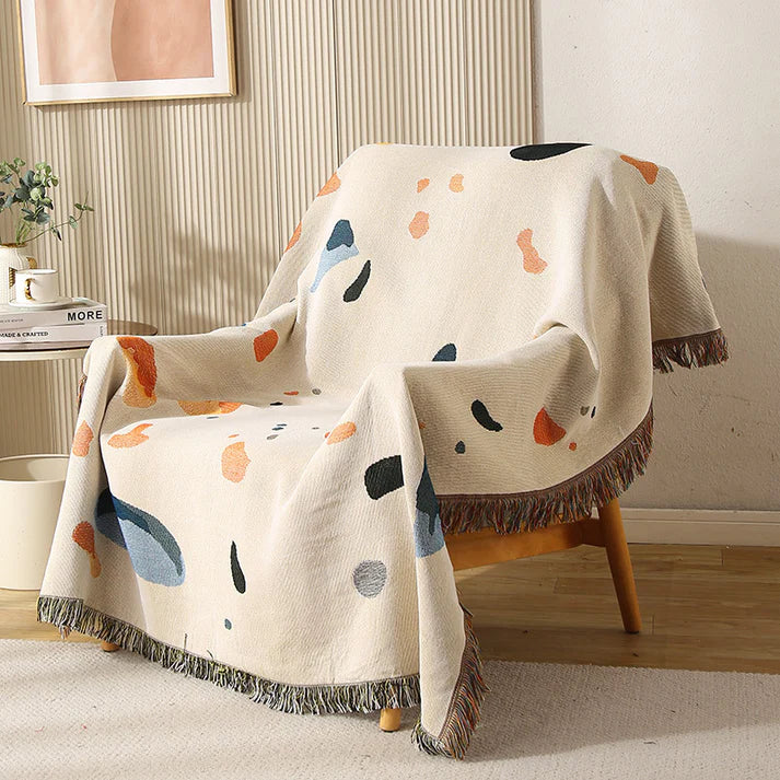 Boho fringe throw blanket draped over armchair in living room setting