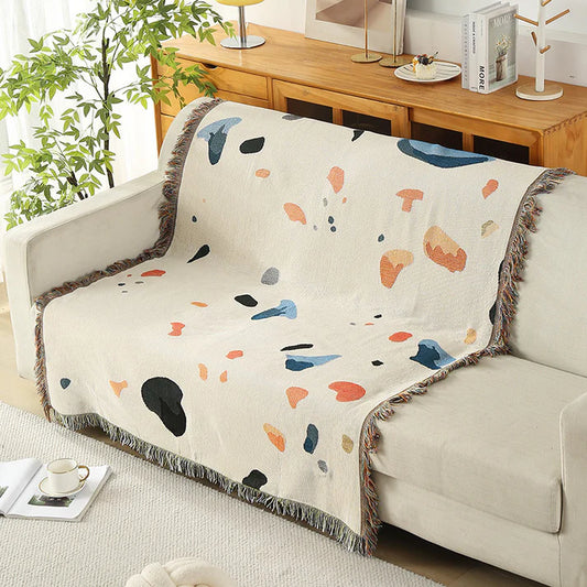 Boho fringe throw blanket cream abstract paint splash draped over sofa
