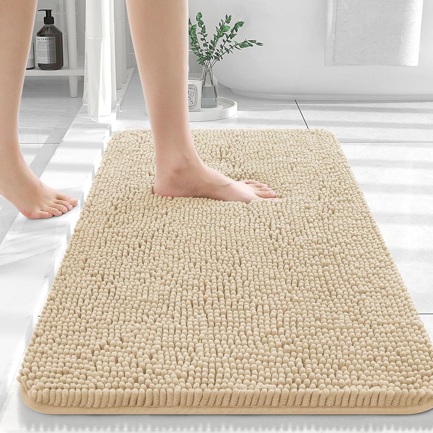 Camel colored chenille floor mat on dark hardwood flooring beside a bathroom vanity
