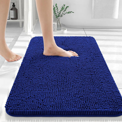 Sapphire blue chenille non slip bath mat in a modern bathroom with dark tile
