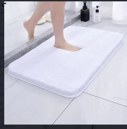Silver gray chenille floor mat beside a bed used as a soft bedroom pedal mat

