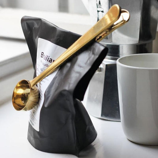 Close up of stainless steel coffee scoop and measuring spoon detail
