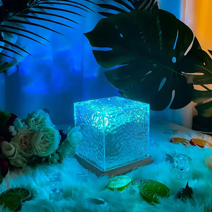 Compact five watt water flame lamp showing size scale next to bed