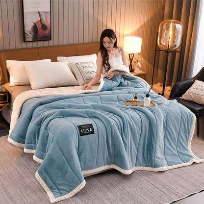 Coral fleece blanket in blue grey on bed