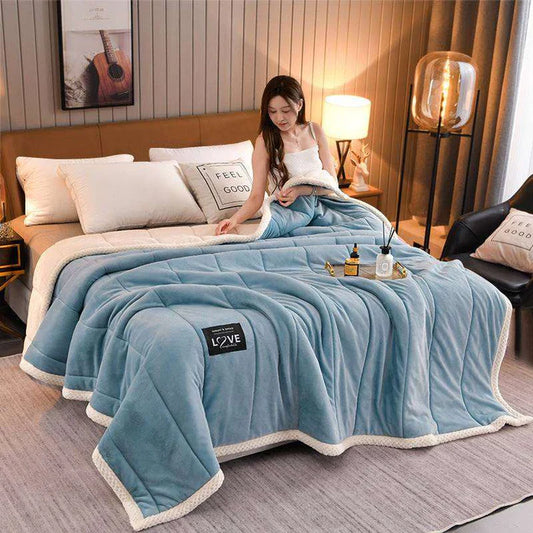 Coral fleece blanket in blue grey on bed