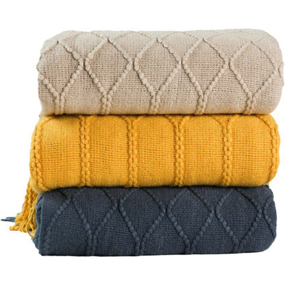 Lake green soft coral fleece blanket folded on a cream sofa arm in a neutral living room
