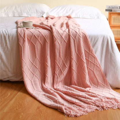 Large size 51x79 inch coral fleece throw blanket layered across a full bed at the foot

