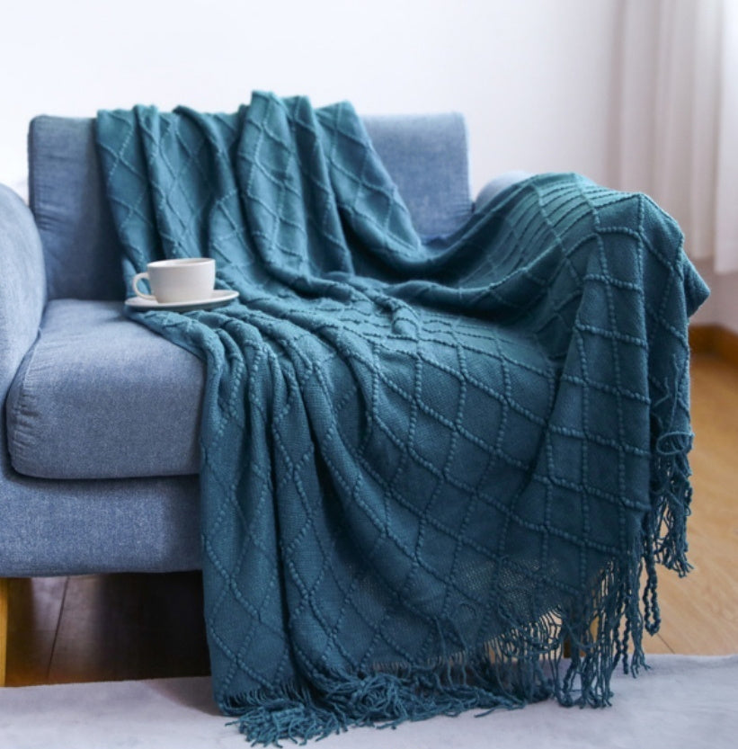 Medium size 50x60 inch coral fleece blanket draped over a sofa showing full coverage
