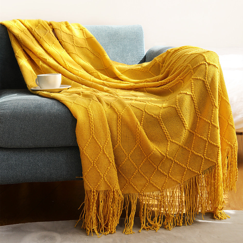 Navy blue coral fleece throw blanket draped over a light gray sofa in a living room
