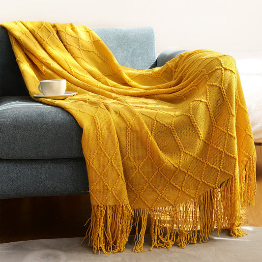 Navy blue coral fleece throw blanket draped over a light gray sofa in a living room

