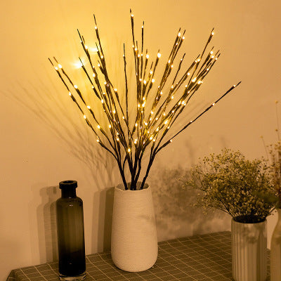 Decorative tree twig lights glowing warmly in nordic style vase decor


