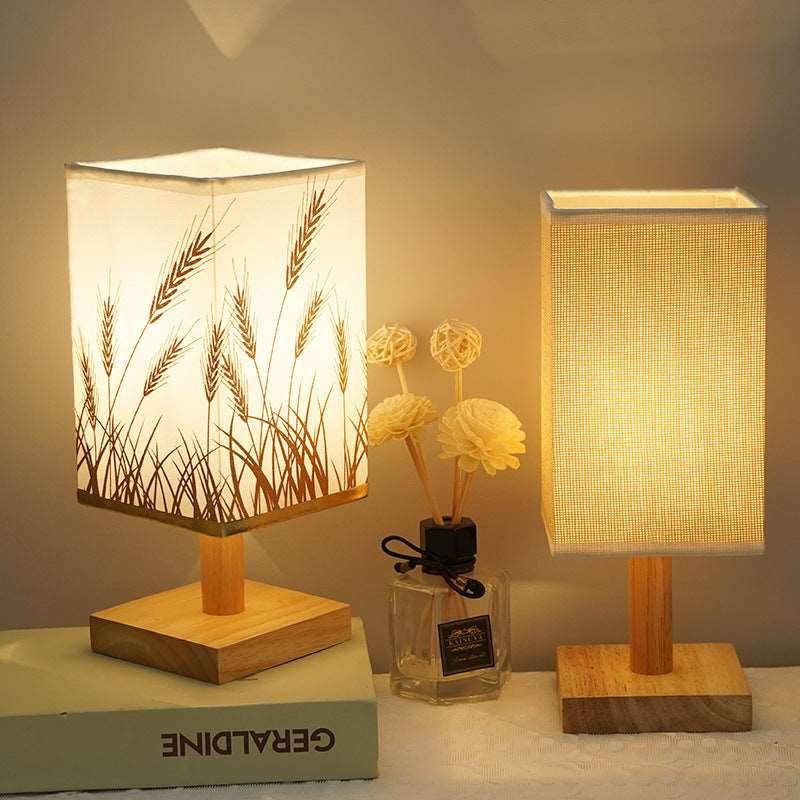 Energy saving LED light lamp with fabric shade sitting on a wooden desk