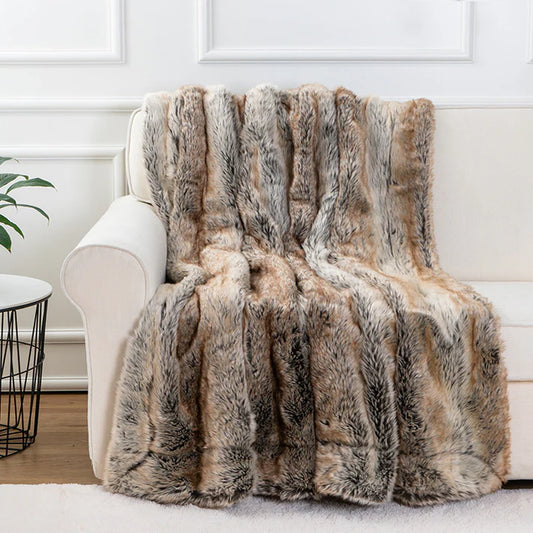 Faux fur throw blanket in brown draped over bed showing soft plush texture
