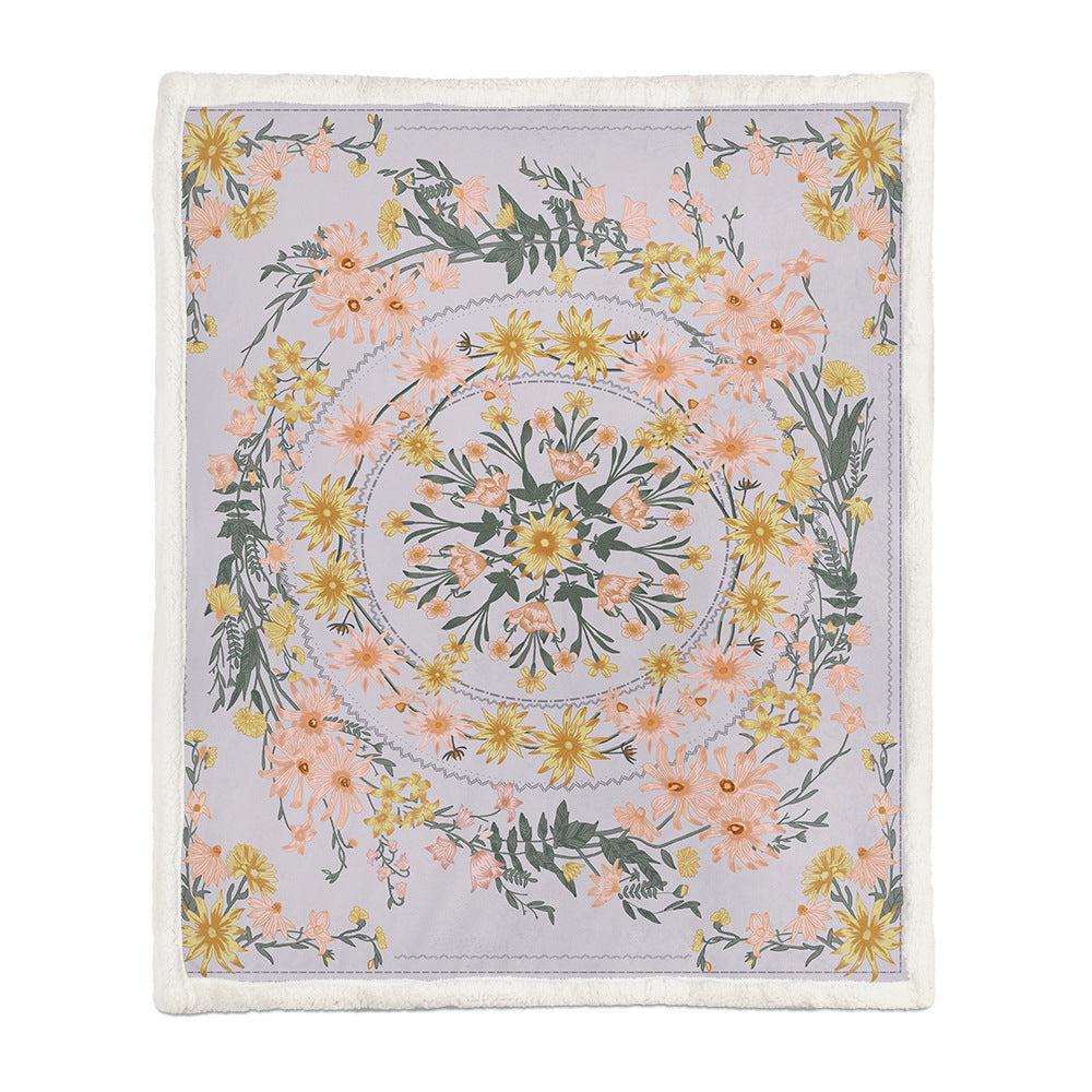 Soft floral throw blanket draped over a bedroom window seat with a small plant beside it
