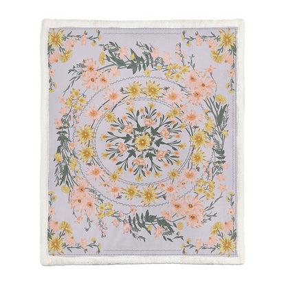 Soft floral throw blanket draped over a bedroom window seat with a small plant beside it
