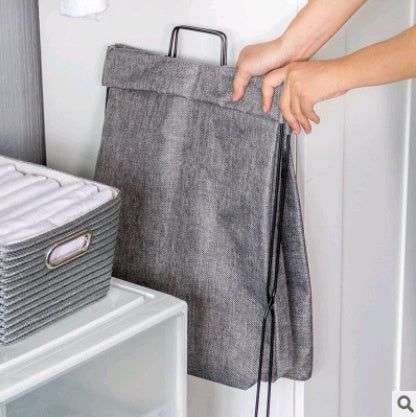 Foldable fabric laundry hamper collapsed completely flat for storage under a bed
