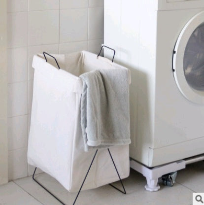 Person carrying a full foldable fabric laundry hamper by the built-in handles to the laundry room
