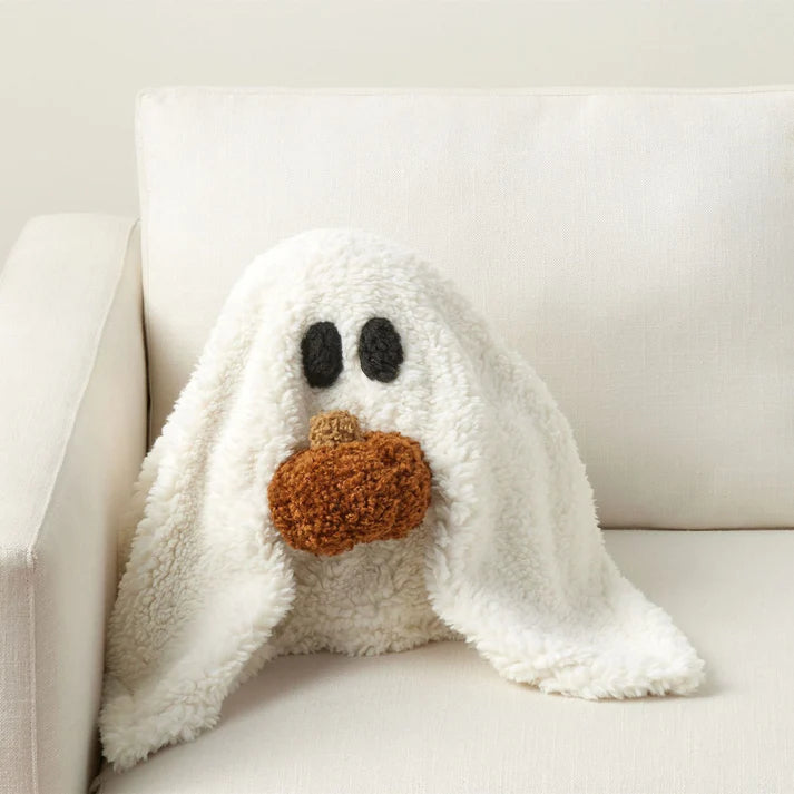Cute plush ghost pillow Halloween with pumpkin detail on white sofa display