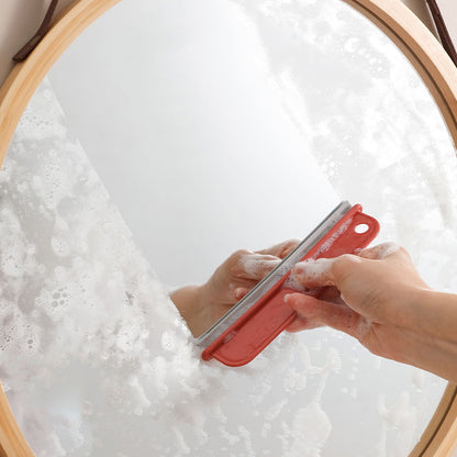 Glass scraper cleaning kitchen window surface