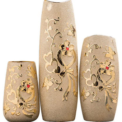Gold ceramic vase styled on dining table with flowers home decoration